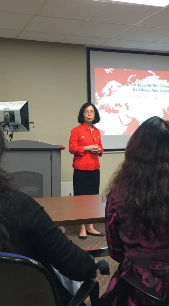 Professor Huping Ling speaking at a lectern